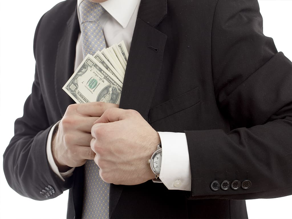 A businessman pocketing a stack of $!00 bills